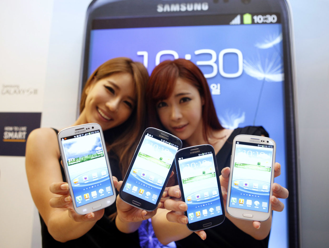 Models hold new Galaxy S III devices as they pose for photographers during an event to launch the smartphone in the local market at the headquarters of Samsung Electronics in Seoul June 25, 2012. Samsung Electronics expects sales of its new Galaxy S III, launched at the end of last month as a main rival to Apple's iPhone, to top 10 million during July, making it the South Korean group's fastest selling smartphone. REUTERS/Lee Jae-Won (SOUTH KOREA - Tags: BUSINESS TELECOMS SCIENCE TECHNOLOGY) - RTR344E2